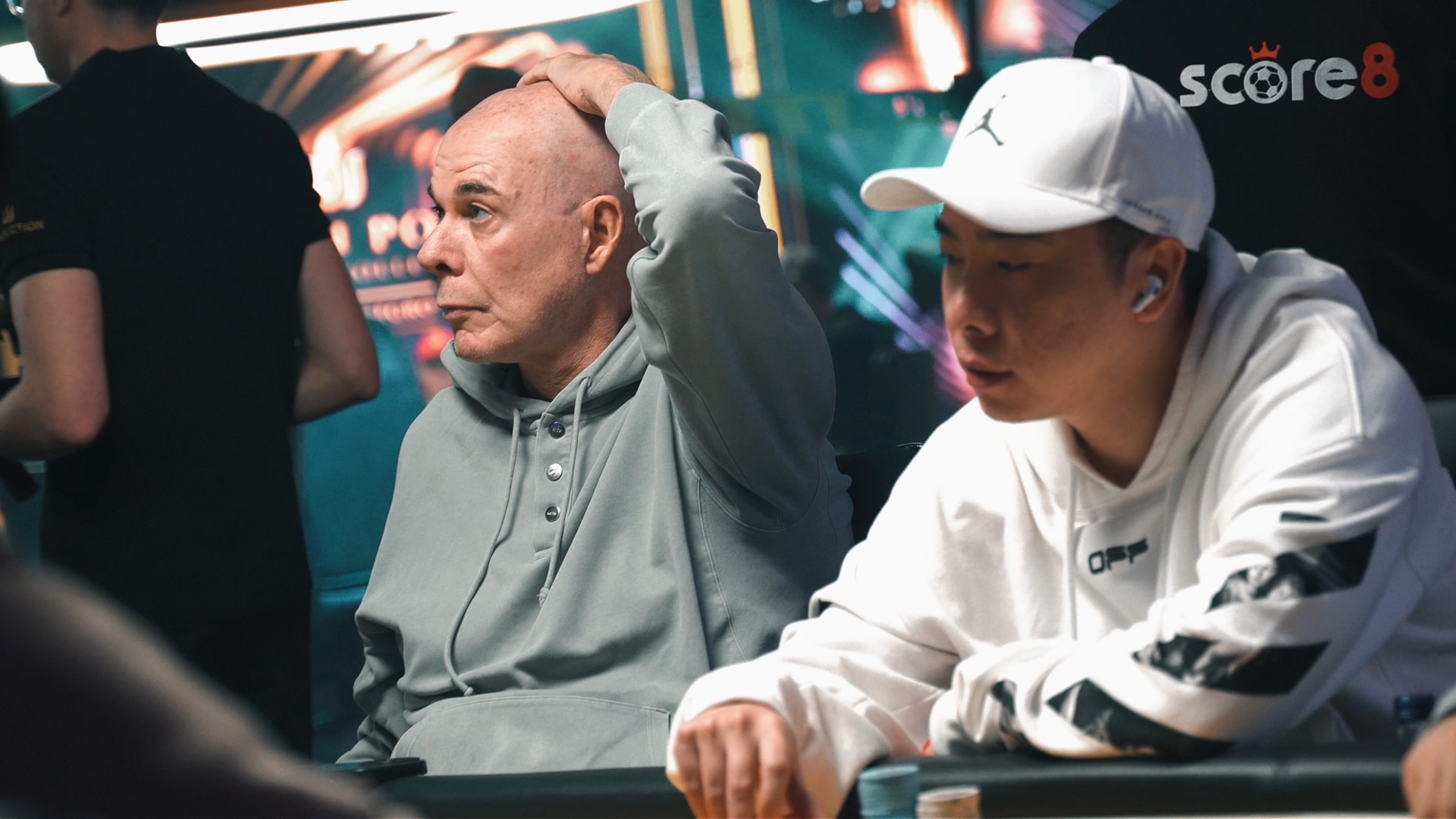 Players at a Triton Poker table with Score8 branding